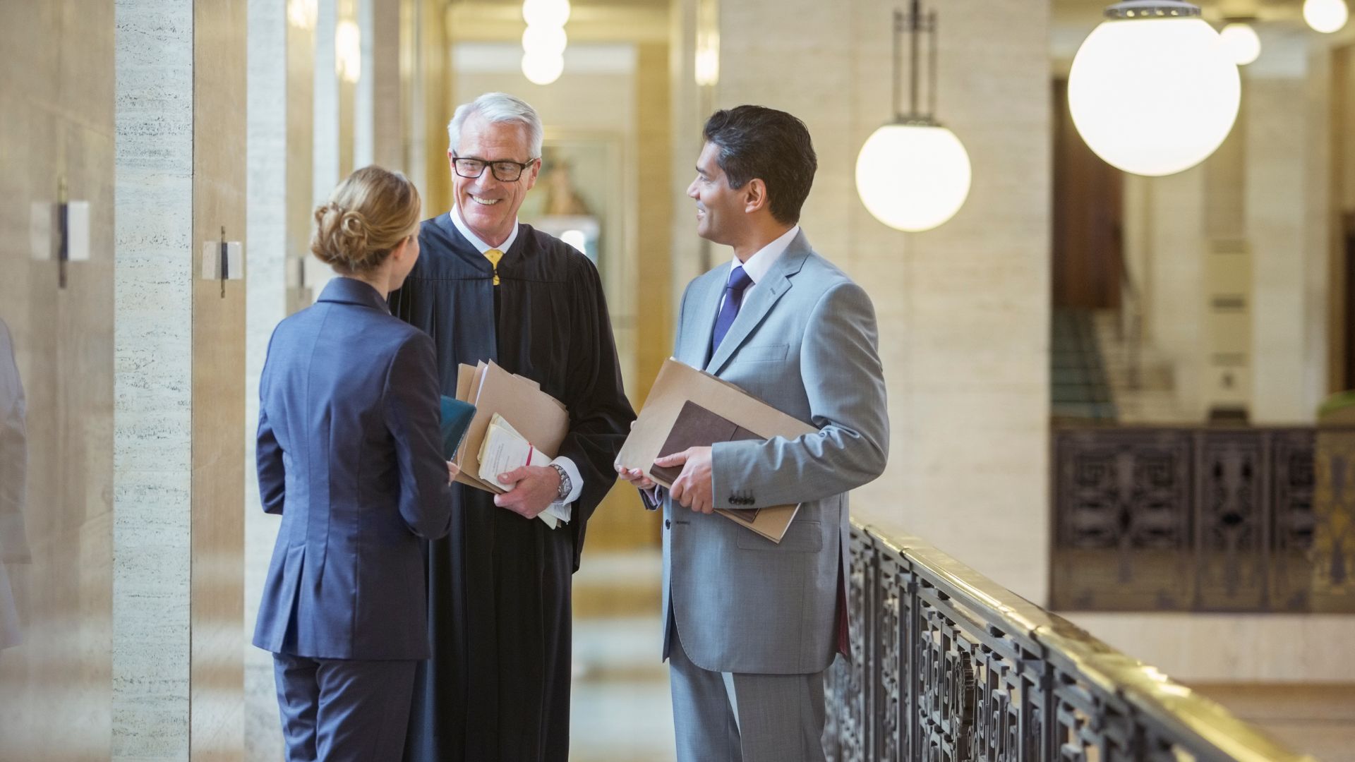 Judge speaking with attorneys in a courthouse, related to what happens if you miss jury duty